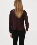 Jersey de punto bordó con cuello polo y cierre frontal de botones ocultos, de manga larga y diseño recto.