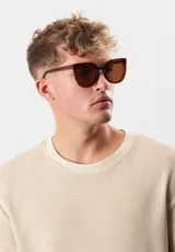 Lentes de sol con montura cuadrada color verde oliva y lentes grises. Fabricados con materiales reciclados.