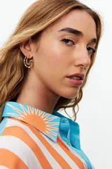 Aros plateados con forma de argolla irregular y textura ondulada.