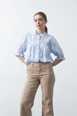 Pantalón de mujer color beige, de corte recto y tiro alto, con costuras frontales marcadas que recorren la pierna.