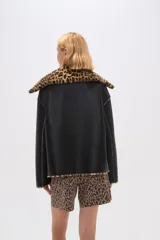 Campera de eco-cuero negra con cuello y puños de animal print, cierre frontal con cremallera y bolsillos laterales.