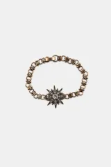 Set de tres pulseras metálicas de color dorado envejecido con detalles de brillos y dijes de estrellas.