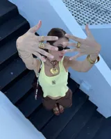 Collar artesanal con dije de bronce macizo en forma orgánica irregular, similar a una concha marina, suspendido de un cordón de seda natural negro. El diseño permite diversas formas de uso, ya sea ajustado al cuello o largo.