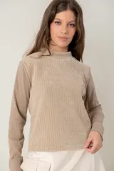 Polera de manga larga con diseño combinado, presentando un panel frontal de tejido acanalado en tono beige y mangas de tela lisa en tono arena. Posee cuello alto y corte recto.