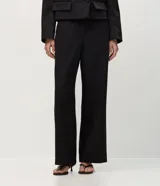 Pantalón de sastrería corte recto, color marrón, con cintura de tiro medio, trabillas largas y bolsillos traseros.