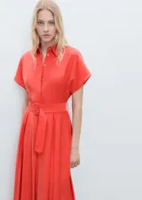 Vestido midi de modal con diseño evasé, cuello camisero y cierre frontal de botones. Presenta mangas cortas, detalle de tablas en la falda y cinturón ajustable con hebilla a tono.