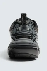 Zapatilla deportiva tipo running color blanco hueso con detalles en azul marino y amarillo flúor.