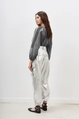 Pantalón cargo de poliamida plateado con efecto metalizado y acabado arrugado. Presenta cintura ajustable con lazo y puños ajustables en los tobillos.