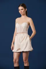 Top tipo corset strapless de encaje con estructura de varillas visibles y copas preformadas, con borde superior de encaje festoneado.