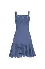 Vestido corto de lino color azul marino, con tirantes y escote cuadrado. Presenta bordados florales en tono sobre tono con aberturas caladas en el pecho y en el volado del ruedo.