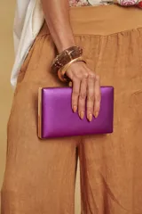 Cartera clutch rígida de diseño rectangular con acabado metalizado y estructura dorada.