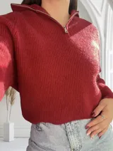 Sweater de punto color bordó con cierre de cremallera metálica en el cuello.