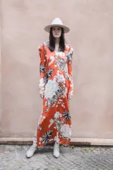Vestido largo de seda color ladrillo con estampado de tigres, flores y palmeras. Tiene escote en V, mangas largas y tajos laterales.