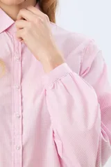 Camisa de manga larga con estampado de cuadros vichy en tono rosado, cuello camisero tradicional, cierre frontal con botones y frunces en los hombros.