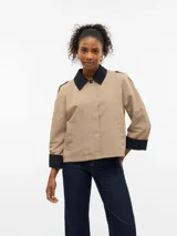 Campera corta de estilo parka con cuello camisero y puños en contraste de color negro. Presenta cierre frontal con botones, bolsillos laterales y detalles de charreteras en los hombros.