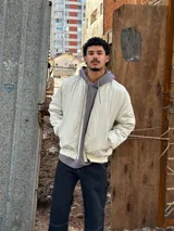 Campera bomber color crudo de nylon con cierre frontal y bolsillos laterales.