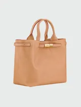 Tote bag de cuero color tostado, con diseño estructurado, doble asa de mano y cierre frontal con hebilla metálica dorada.