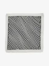 Pañuelo cuadrado de tela liviana con estampado de puntos blancos sobre fondo terracota, enmarcado por bordes en contraste en tonos azul oscuro y beige.