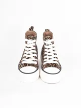 Zapatilla de caña alta con plataforma, confeccionada en lona negra con cordones y puntera de goma blanca.