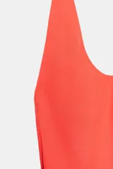 Vestido largo color salmón con cuello halter, escote redondo y espalda descubierta. Cuenta con bajo acabado asimétrico, cierre en el cuello con botón y cremallera oculta en la espalda.