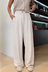 Pantalón de lino color crudo, de corte palazzo, tiro alto y pinzas en la cintura.