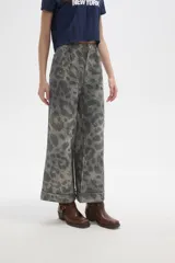 Pantalon de jean de corte ancho y tiro alto, con diseño estampado animal print en tonos grisáceos. Presenta pinzas en la cintura y ruedo con doblez.
