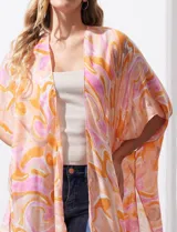 Kimono tejido con estampado abstracto en tonos naranja, rosa y blanco, con mangas amplias estilo japonés y terminación con borlas.
