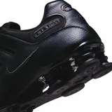 Championes Nike Shox NZ completamente negros, con capellada de cuero sintético y malla, sistema de amortiguación Shox en el talón y suela de goma resistente.