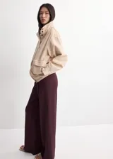 Pantalón de punto fino color bordó, de diseño recto y largo, con talle medio y detalle de pinzas.