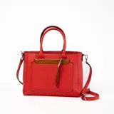Cartera tipo tote de cuero sintético color rojo con doble asa corta y correa larga desmontable. Tiene un bolsillo externo con cierre y tirador de cuero.