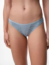 Colaless de tiro medio confeccionada en algodón acanalado color celeste, con detalles de encaje floral en los laterales y ribete suave en la cintura.
