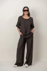 Blusa de lino color blanco, de corte amplio, con escote redondo, mangas cortas y detalle de guarda calada horizontal en la parte inferior.