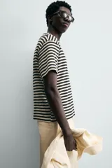 Camiseta de manga corta con cuello redondo y calce relajado, confeccionada en tejido de rayas horizontales blancas y negras.