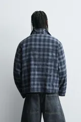 Camisa boxy fit de cuadros en tonos azules y negros, confeccionada en tejido con mezcla de algodón. Cuenta con cuello solapa, manga larga y cierre frontal con cremallera.