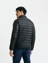 Campera acolchada tipo puffer en color gris, con cierre frontal, cuello alto y puños elásticos.
