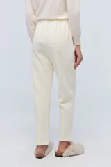 Pantalón de jogging color crema, de tela elastizada con bordados florales, corte recto y cintura elastizada.