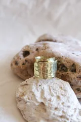 Anillo ancho de bronce con textura martillada.