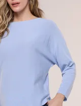 Buzo tejido liviano de calce holgado color celeste, con escote bote y mangas tipo dolman.