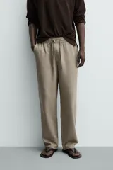 Pantalón de corte regular fit confeccionado en tejido mezcla de algodón, con cintura elástica ajustable mediante cordón, bolsillos laterales y bolsillos traseros de vivo.