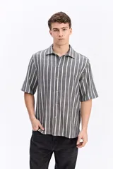 Camisa de manga corta de tejido rústico con diseño de rayas verticales, cuello clásico y corte recto.