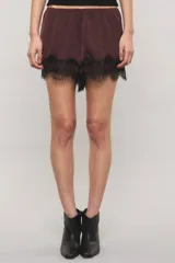 Short de satén texturado color bordó, de tiro medio con cintura elástica y detalles de puntilla negra estilo chantilly en el ruedo.