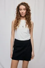 Short cruzado de tiro medio con diseño frontal tipo falda, color negro, de líneas simples y calce cómodo.