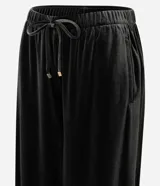 Pantalón de corte recto confeccionado en terciopelo, con cintura elástica ajustable mediante lazo y bolsillos laterales.