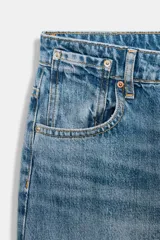 Jeans de tiro alto, color celeste claro con efecto desgastado y lavado. Modelo de corte holgado (loose baggy) con cierre frontal de botones metálicos y cinco bolsillos.