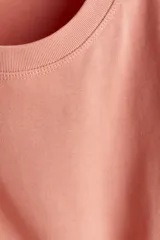 Remera color salmón de punto de algodón suave, corte amplio con hombros caídos y cuello redondo.