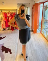 Minifalda negra de lino y algodón, con bordado de pequeñas cuentas blancas en el ruedo.