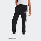 Pantalón deportivo Adidas modelo Essentials, color negro con las tres tiras características de la marca en blanco a los costados. Presenta cintura elástica con cordón de ajuste, puños acanalados en los tobillos y logo de la marca bordado en el frente.