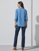 Camisa de manga larga de lyocell color azul claro, con cuello con solapa, escote en V y abertura central con botones. Presenta dos bolsillos aplicados en el frente.