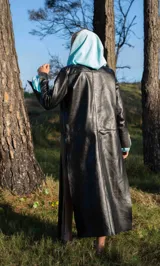 Tapado marrón de cuero con corte a la rodilla, mangas largas y aberturas laterales.