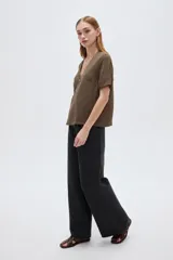 Blusa marrón de manga corta con cuello en V y cierre frontal cruzado con tres botones.